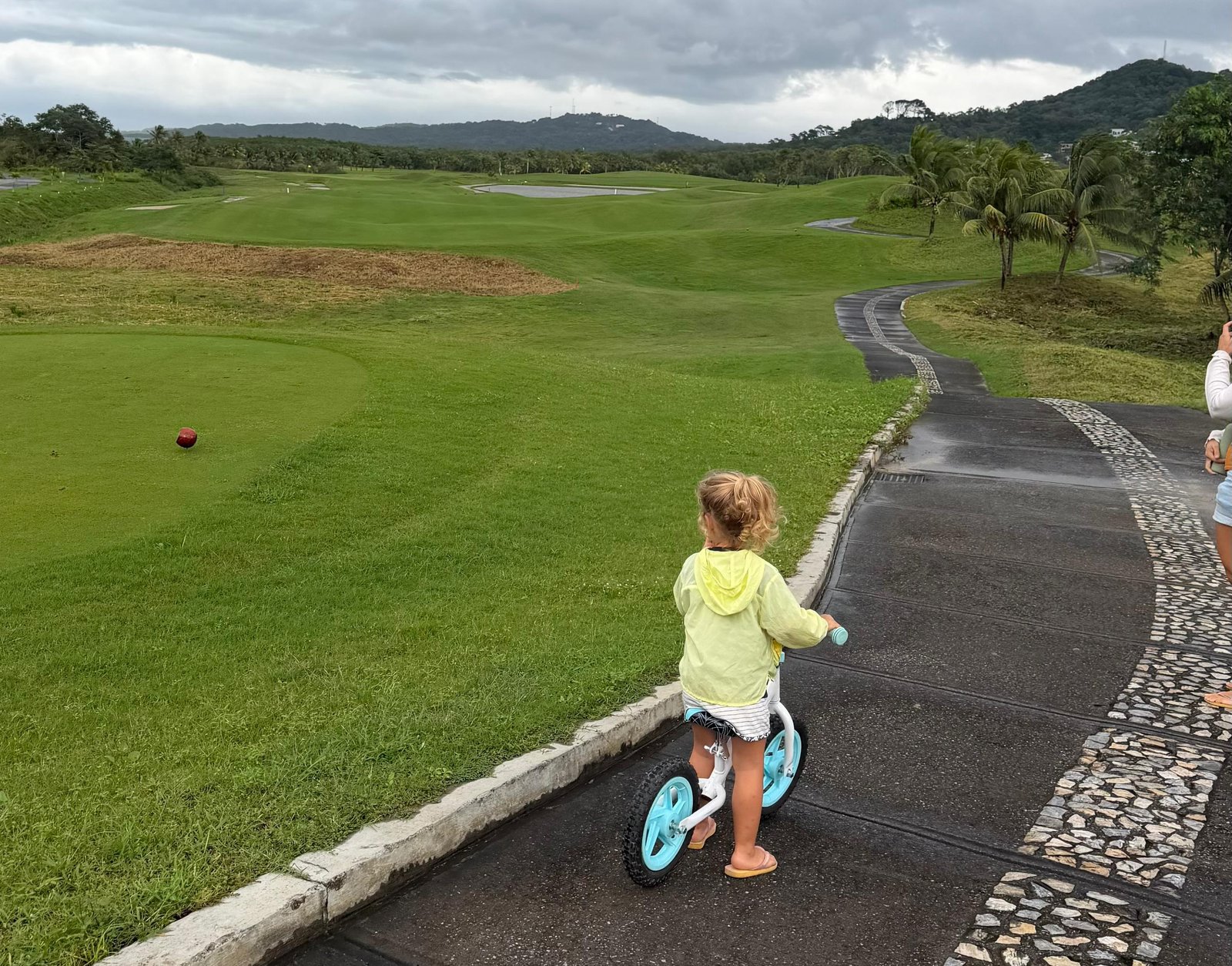 Child riding a bike on the golf course at Próspera